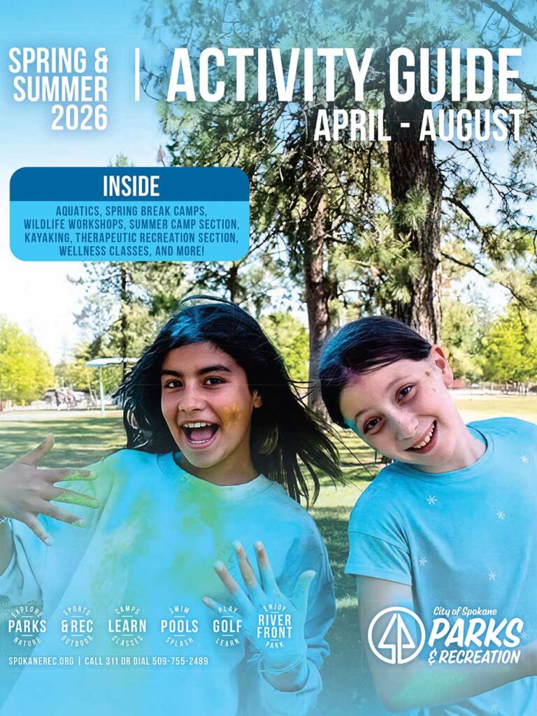 Image: The cover for the Spokane Spring and Summer Activity guide with two young people smiling in a park. 